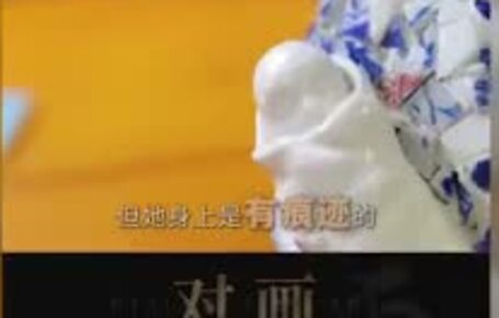Video still: the high-white porcelain baby resting in the mother's arms